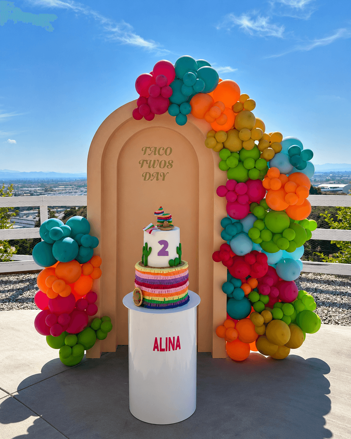 Alina Taco Twos Day party cake and balloon setup by Lovelle Patisserie